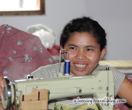 A smiling student behind a sewing machine