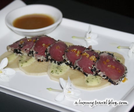 Seared tuna in black and white sesame with daikon slices, ginger sauce and jasmine flowers