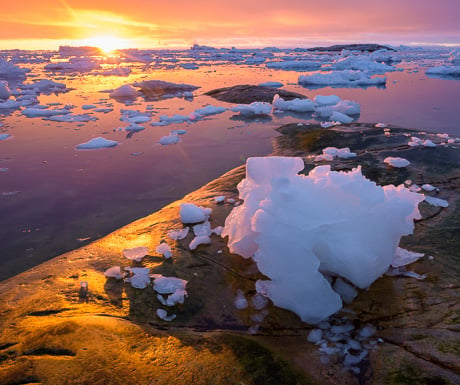 Sunset over stranded "growler" ice on the shore at Ilulissat, western Greenland