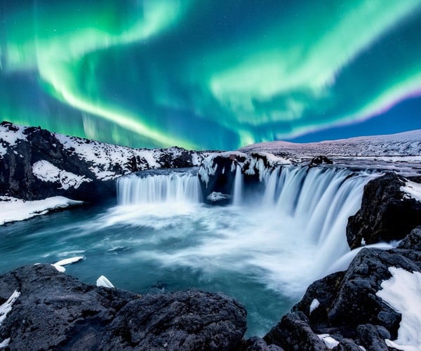 The magnificent Northern Lights above Godafoss waterfall in winter, North Iceland